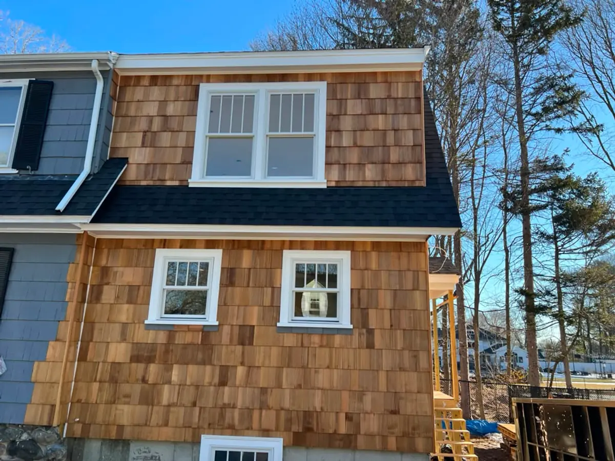 New cedar shingles on a Reading, MA addition running up to the original grey clapboard