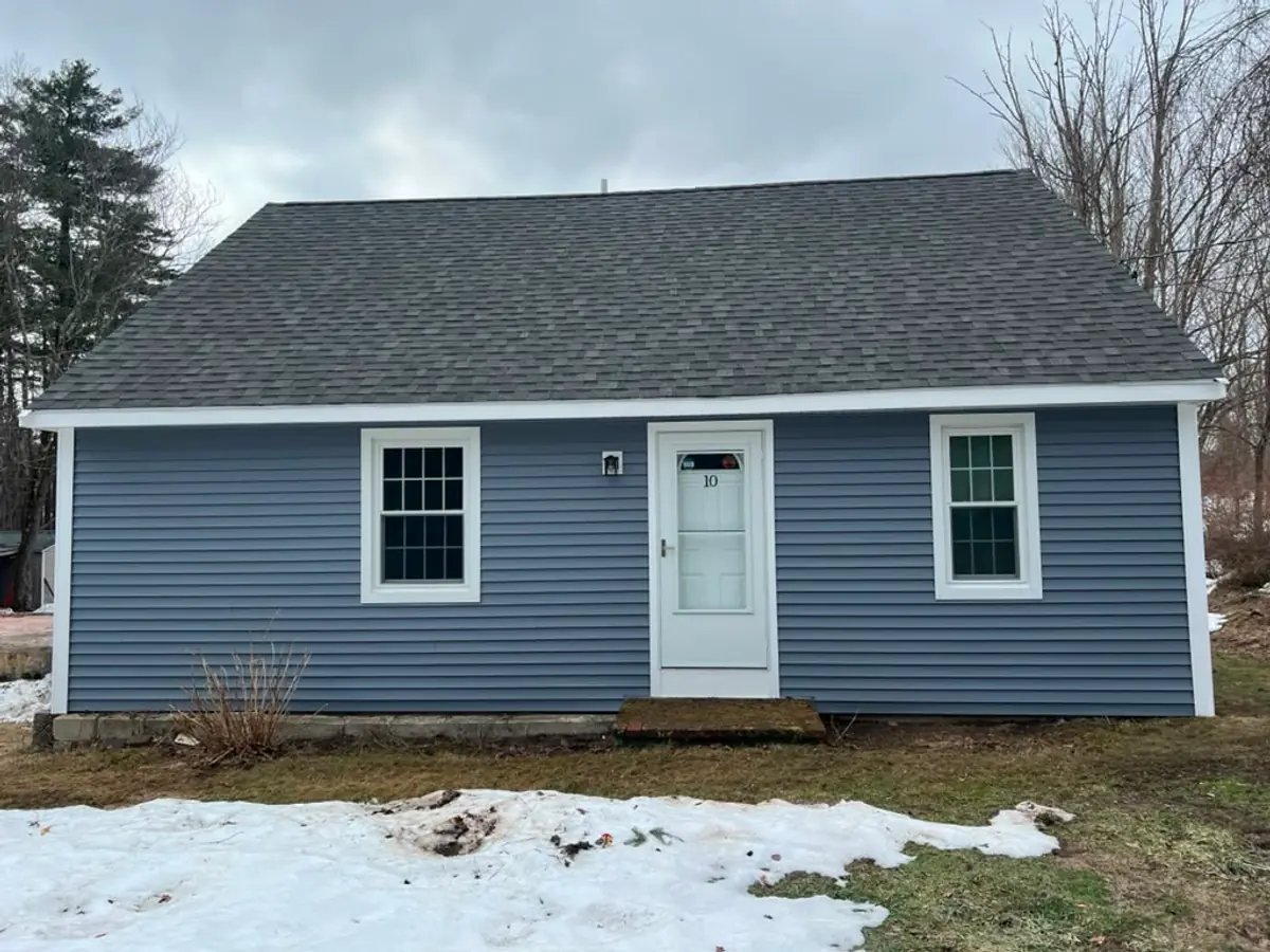 Finished front elevation of a Cape in Atkinson, NH with blue-grey insulated vinyl siding and white trim