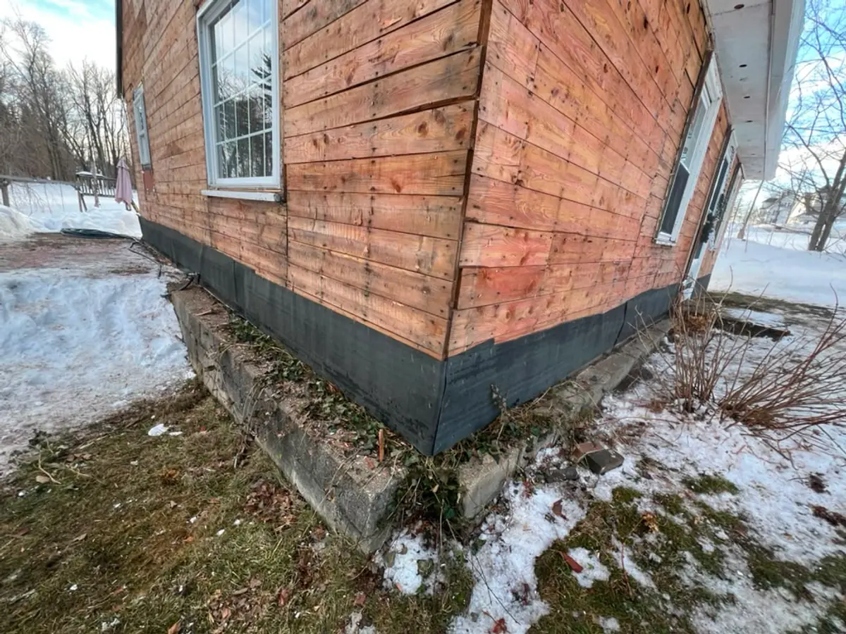 Original plank sheathing exposed at a corner after the old siding was stripped, Atkinson NH