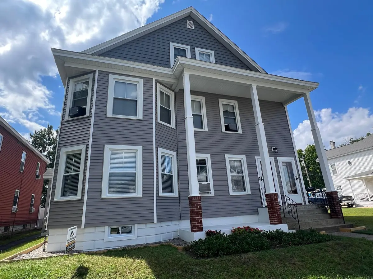 Front elevation in Manchester, NH after residing, with new white window trim