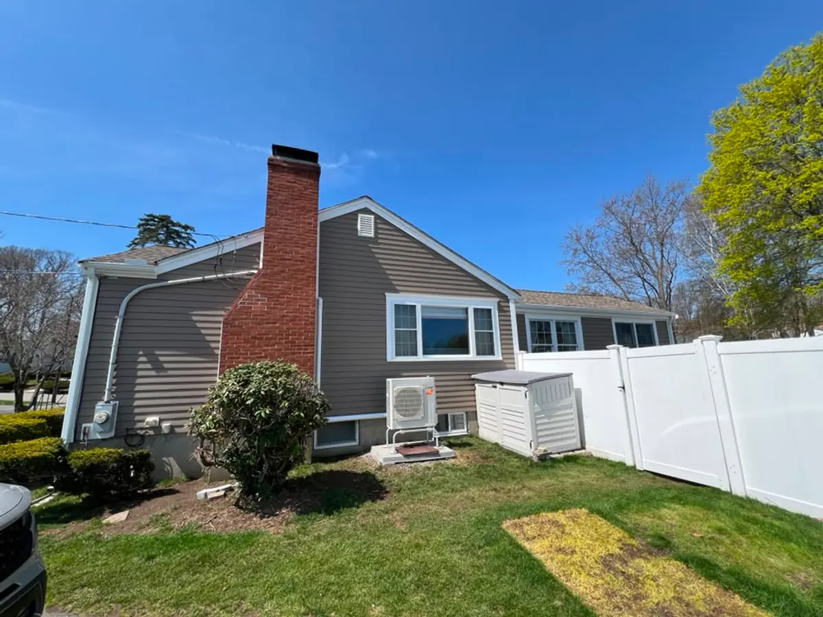New siding cut in around the original brick chimney on a Woburn, MA home