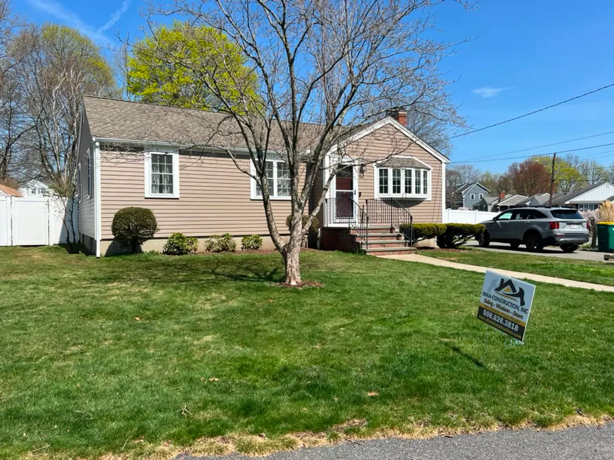 Completed Woburn, MA ranch from the street with new taupe vinyl siding and a bay window